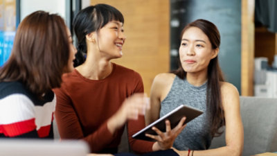 Three people discussing with each other and smiling