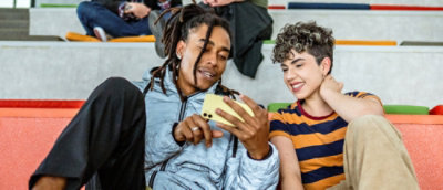 Two people talking to each other while looking at the screen.