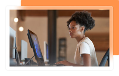 Person working at a desk using a computer monitor in a modern office setting.