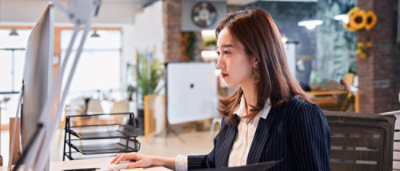 En kvinde, der kigger på en stationær computer.