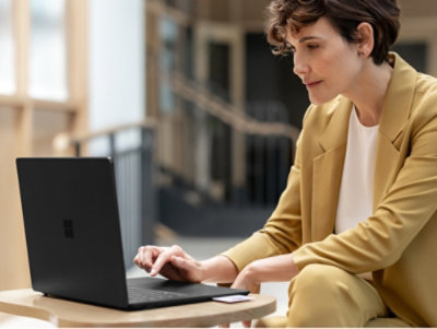 A person sitting at a table using a laptop.