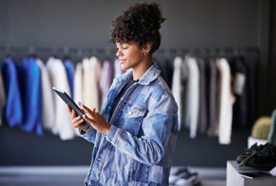 A woman with curly hair holding a tablet.