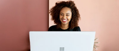 A woman smiling at a computer.