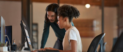 A man and woman looking at a computer.