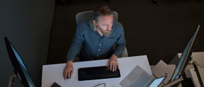 A man sitting at a desk with a keyboard.