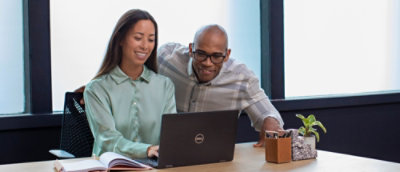 A man and woman looking at a laptop.