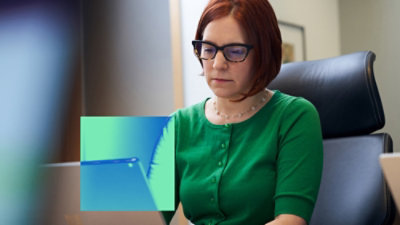 A women sitting at desk work on laptop