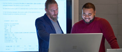 A person showing something on screen to other person.