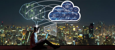 Una persona seduta con un portatile di notte, con al di sopra una nuvola digitale contenente icone che rappresentano varie tecnologie, con la sovrapposizione di paesaggio urbano