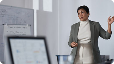 A woman standing infront of white screen.