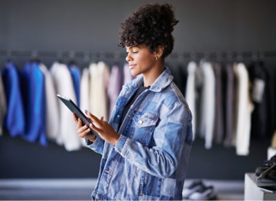 En kvinde, der står og holder tablet i hånden.