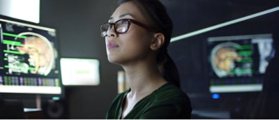 En kvinde med briller kigger op.