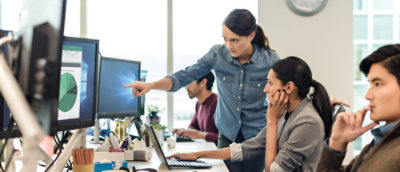 Egy nő egy számítógép képernyőjére mutat.