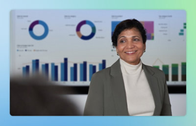 大画面の前に立っているグレーのスーツを着ている人。