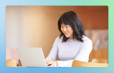 ノート PC で作業をしている女性。