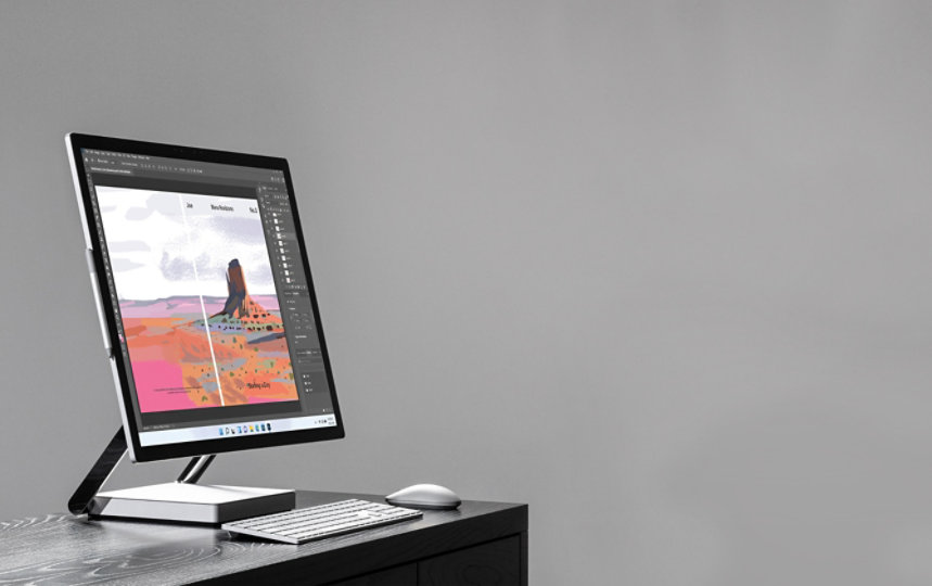 Surface Studio 2 on a desk with a keyboard and mouse.