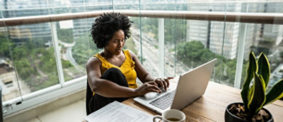 Une femme assise à un bureau utilisant un ordinateur portable.