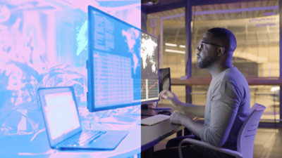 A person is seated at a desk, focused on a large monitor.