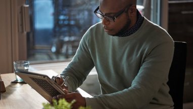 Човек, който използва перо на сгънат лаптоп в режим на таблет