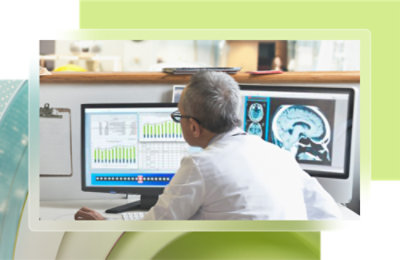 A man in a white shirt looking at a graph on a computer screen.