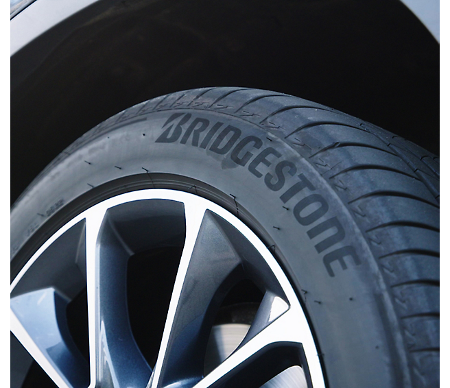Close-up of a bridgestone tire on a car's alloy wheel.