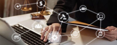 A professional working on a laptop with digital icons representing finance and law concepts floating above the screen.