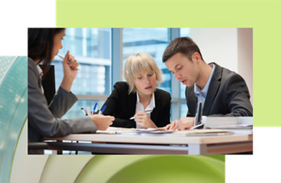 一男一女两名专业人员专注地审阅文档，另一位女士坐在旁边倾听。