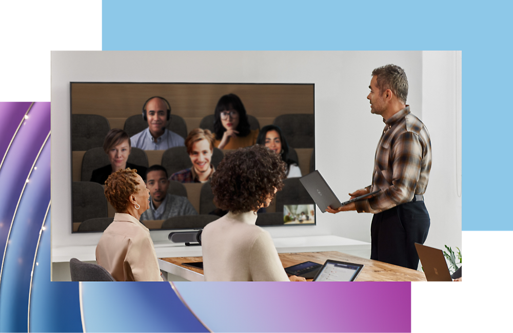 Un hombre hace una presentación a sus compañeros delante de una pantalla que muestra una videollamada con otros seis participantes.