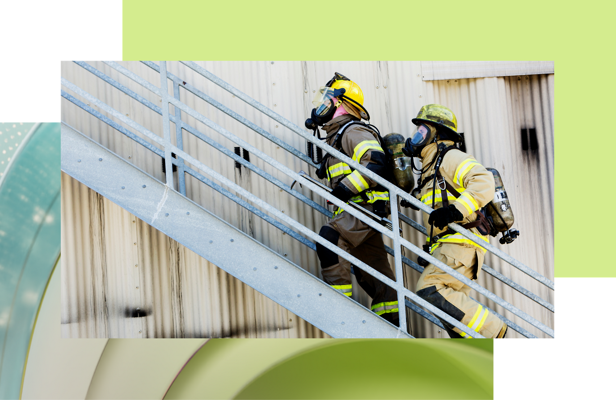Two firefighters in full gear ascending an outdoor metal staircase during an emergency response drill.