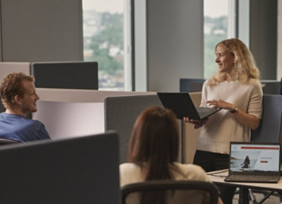 Žena drží přenosný počítač.