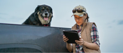 Женщина смотрит на планшет со своей собакой