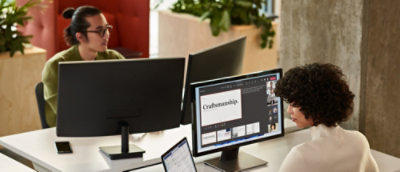 Grupa ljudi sedi za stolom sa računarima