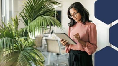 A person holding a tablet in a room.