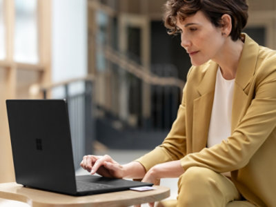 A person sitting at a table using a laptop.