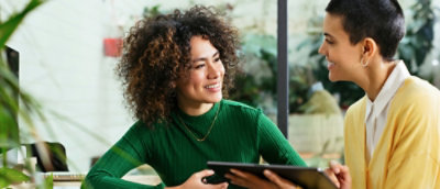 A woman with short curly hair smiling in a green shirt.