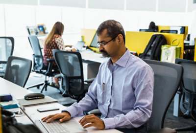 A person sitting at a desk using a laptop.