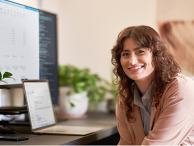 Women working in laptop and looking at the camera and smiling