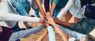 A group of people putting their hands together.