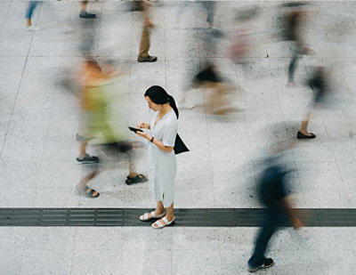 A woman in a white dress using a tablet.