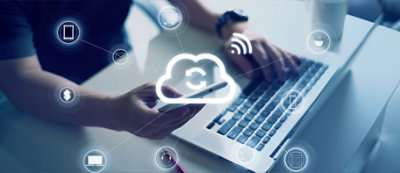 Una persona usa uno smartphone e un portatile, con icone che rappresentano il cloud computing e vari servizi come e-mail, internet