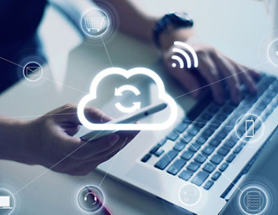 A person using a laptop and a phone.