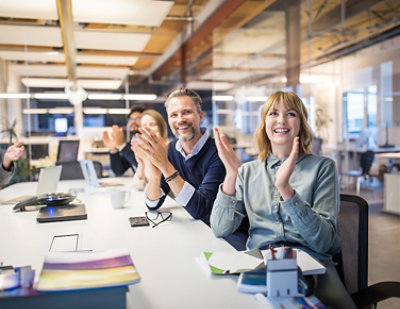 A group of people clapping at a table.
