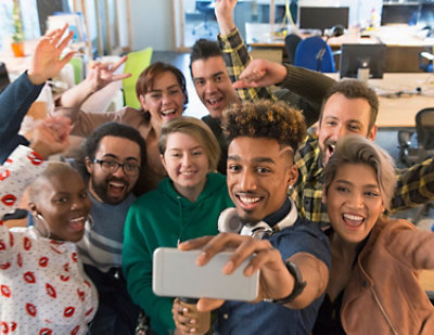 A group of people smiling and taking a selfie.