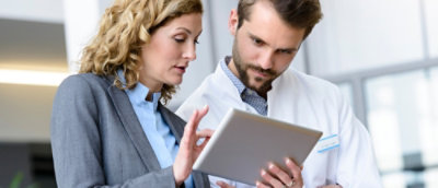 A man and woman looking at a tablet.