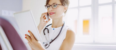 A person holding a tablet and a phone.