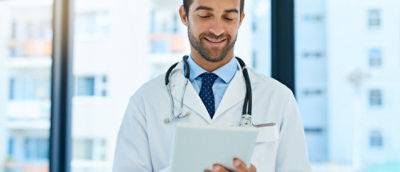 A close-up of a doctor holding a tablet.