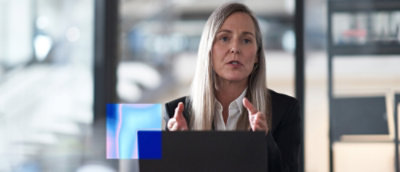 Person speaking during a video meeting on laptop