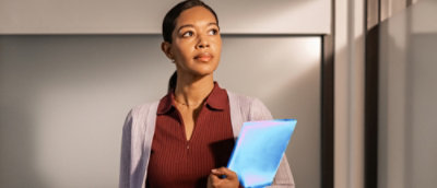 Person holding a glowing laptop in office lighting