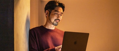 Person using laptop in warm indoor lighting