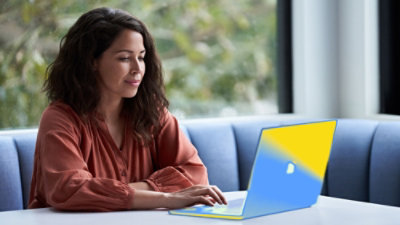 A person sitting at a table using a laptop.